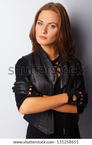 Image of Hot woman who is wearing leather vest and leather gloves