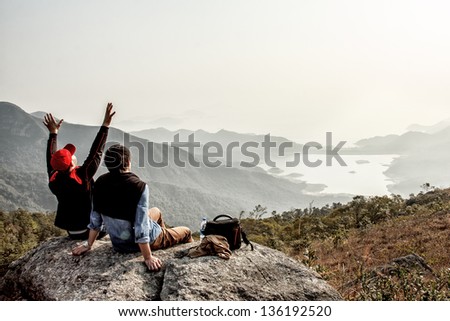 Friends are happy that they got on top of mountain