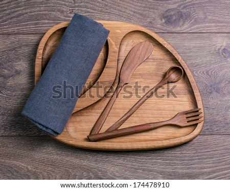 Wooden board with a piece of cloth and wooden cutlery