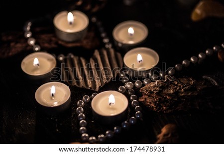 Silver heart surrounded by candles and silver beads
