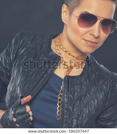 Image of hot chick who is posing in blue dress and leather jacket on dark background
