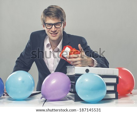 Portrait of sexy man posing in studio in front of table with color balloons