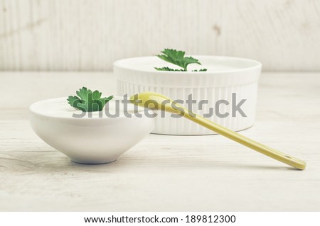 Two bowls of milk product with parsley