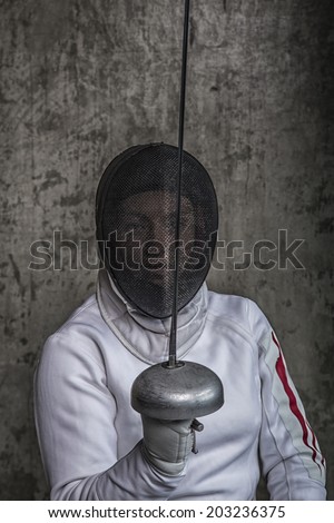 girl athlete in mask with sword on gray background