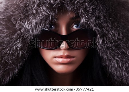 Portrait of young sexy brunette with sunglasses in darkness