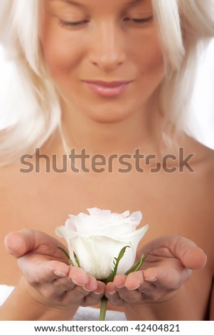 Picture of sexy girl holding flower in her hands. Focus on rose