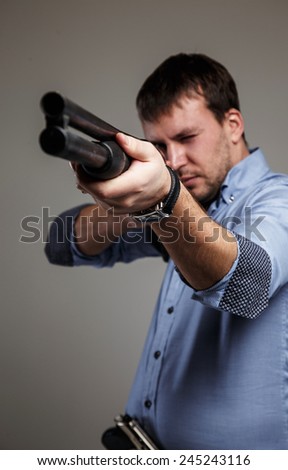 Serious man aims with shoot-gun