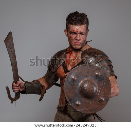 Gladiator prepares to attack his enemy holding sword and shield