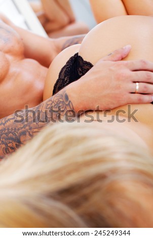 Picture of muscular man holds on knees charming girl with perfect buttocks