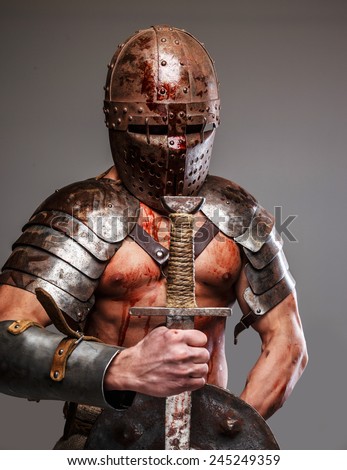 Worn out gladiator after fight holding shield and sword