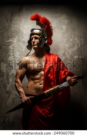The muscular man in Roman armor holding sword.