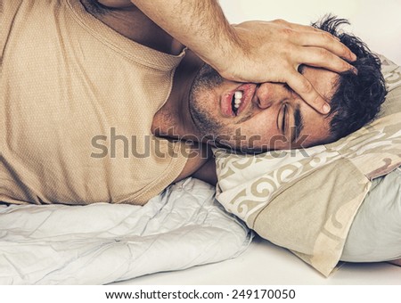 Young man  in bed , trying to sleep