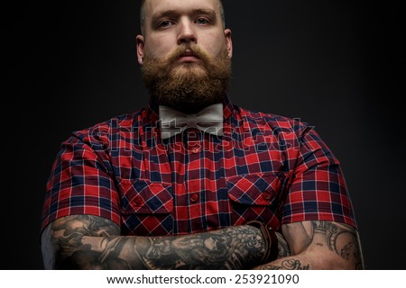 Part of face of the man with beard incolor shirt andgrey  bow tie. Isolated on dark gray background