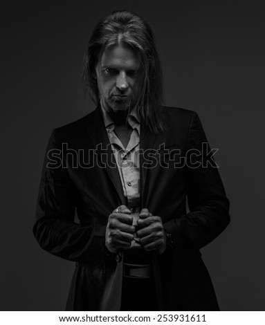Black and white portrait of long hair middle age male possing in studio.