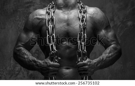 Body of muscular man with chain on gray background watching up.