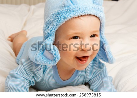 Cute cheerful  little baby boy in blue clothes.