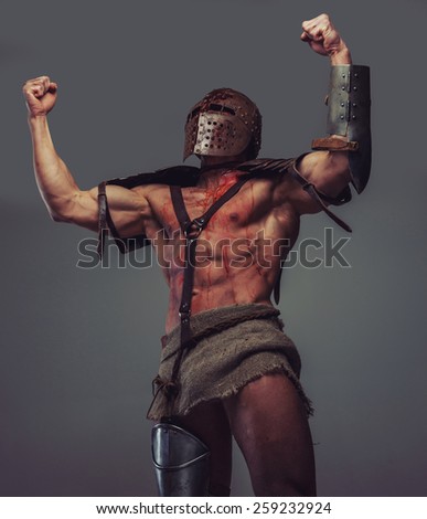 Victorious muscular gladiator with blood on his body