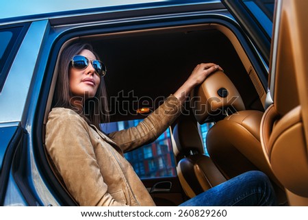 Awesome girl in sunglasses in a car back seats.