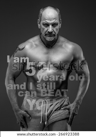 Middle age male with muscular body posing in studio. Isolated on grey