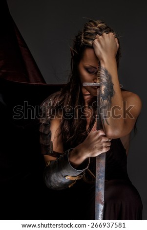 Elf woman in armor holding sword. Isolated on grey