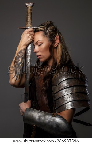 Elf woman in armor holding sword. Isolated on grey