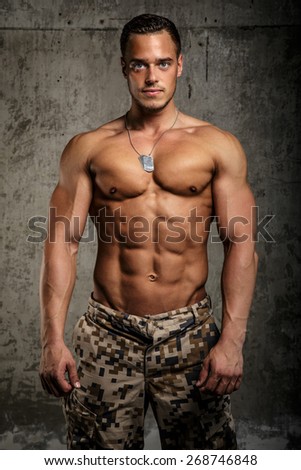 Man in army pants with naked torso. Vertical shoot