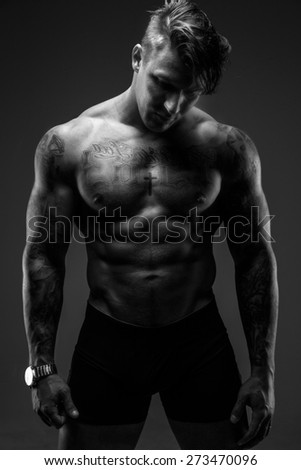 Black and white shoot of muscular man with tattooes.