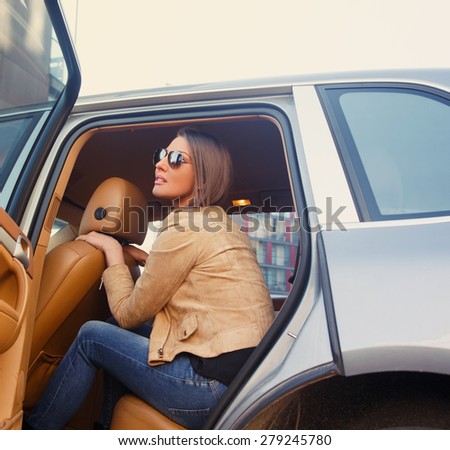 Fashion female posing on back seats of the car