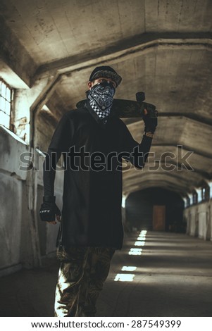 Guy in gangster clothing and face mask in catacombs