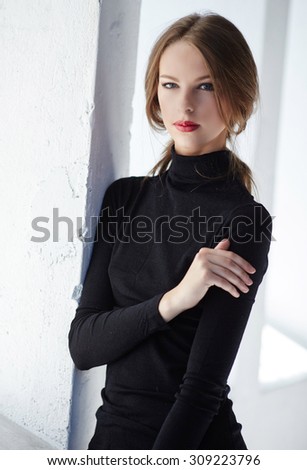 Portrait of woman in black clothing over white background.
