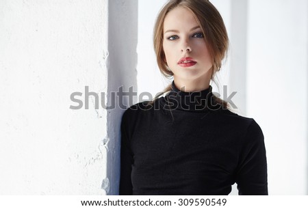 Portrait of brunette slim woman in black clothing.