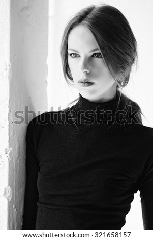 Black and white portrait of slim woman over white background.