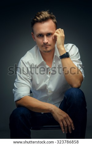 Handsome young man in white shirt over grey background.