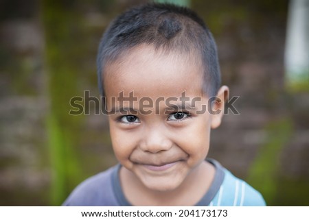 SANGKHLABURI,THAILAND-SEPTEMBER 16: Unidentified young asian boy pose with smiling face on September 16, 2012 Mon village and the longest wooden bridge in Thailand. in Sangkhlaburi,Thailand.