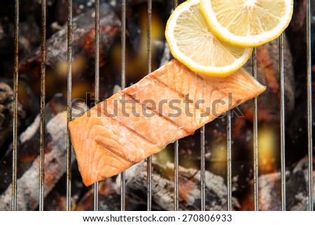 Top view grilled salmon with lemon on the flaming grill