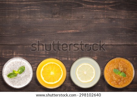 Set of fruit smoothie and juice in glasses on wooden background with a lot of copy space for your text or editing.