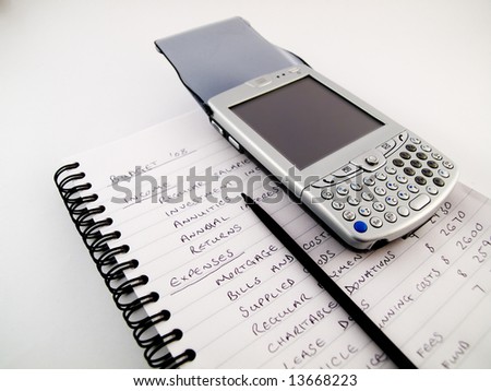 PDA Modern Mobile Cellphone with Stylus on Traditional Paper Lined White Notebook Paper Showing a Home Budget Financial Plan