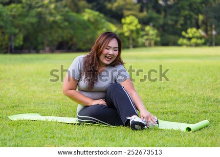 Obese woman relaxing on the grass.