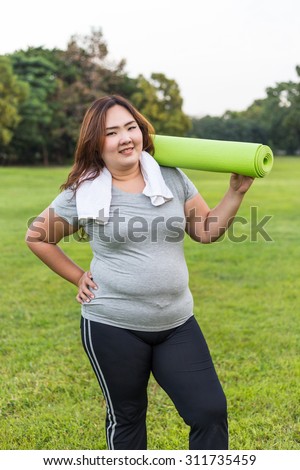 Beautiful fat holding yoga mat on her arm.