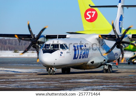NIZHNY NOVGOROD. RUSSIA. FEBRUARY 17, 2015. The passenger ATR-72 plane of the UTair-Express company on the parking and a tail of Airbus A320 of the S7 company