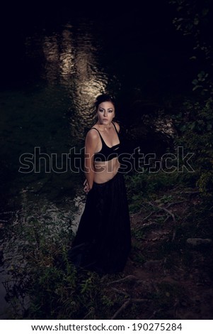 beautiful brunette girl in a dark fairy forest