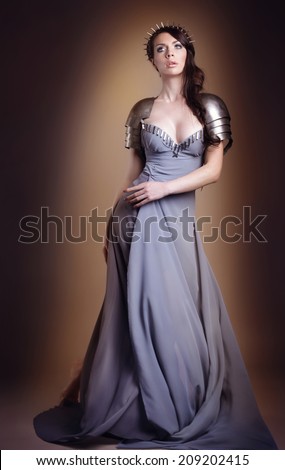 portrait of a beautiful lady warrior, dark-haired girl in a gray dress. bright makeup, hairstyle, spikes