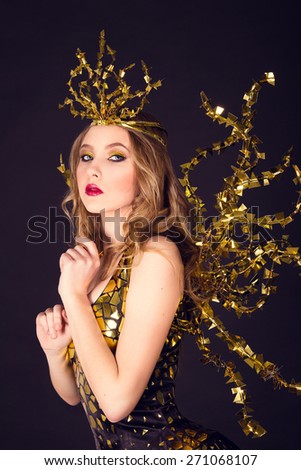 sexy disco party woman dressed in a unique golden costume with metal wings. Perfect for stylish club, disco and fashion events