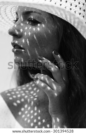 Portrait of a charming young woman outdoor. Light and shadow. interesting portrait of young girl\'s face covered with unusual shadow