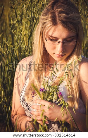Healthy beautiful woman walking outdoors. Alluring young woman in wheat field, delicate sensual woman on nature. perfect skin, curly hair.