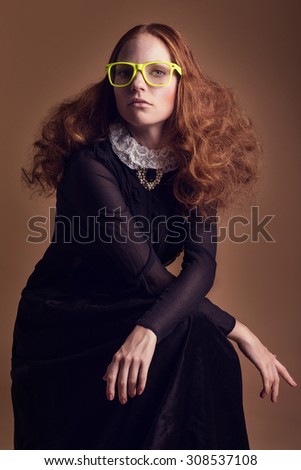 Woman in historical dress with collar in romanticism style. With things from another era - glasses