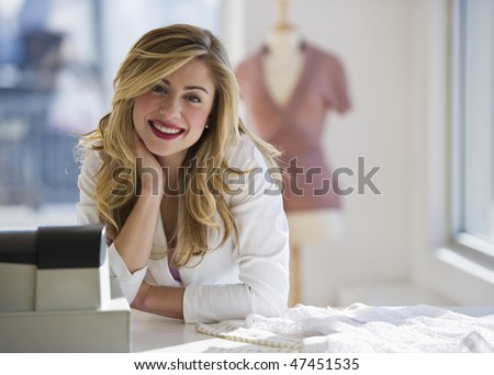 female store employee behind register looking at camera