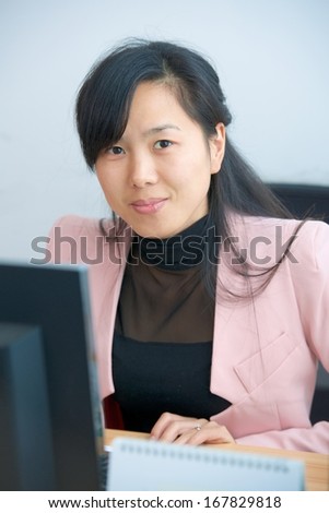 pretty asian manager woman by table with computer