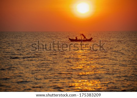 lonely fishing boat at sunset returns home on the south sea