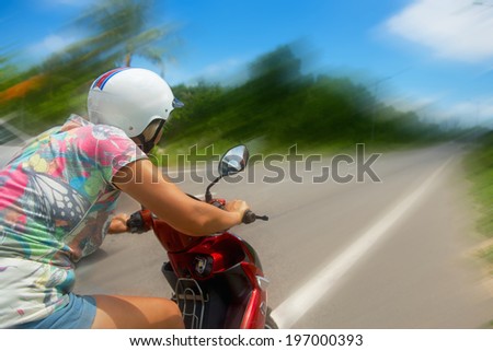 attractive women riding on a motorbike in the tropics